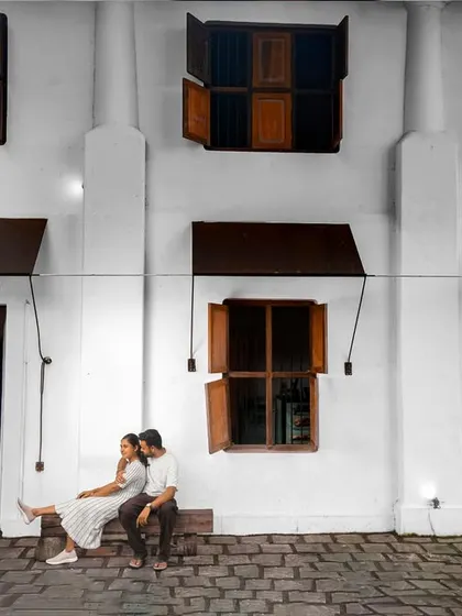 A quiet, romantic moment as the couple sits together, framed by the beautiful architecture of Pondicherry.