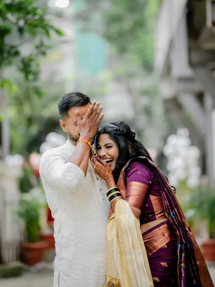 A playful and candid moment where the couple is laughing shyly. These are the unposed memories that truly show a couple's personality.