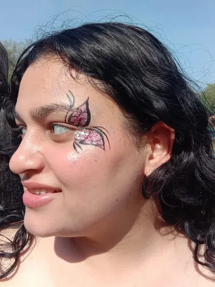 A beautiful pink and silver glitter butterfly. The profile view shows how the art contours to the face, creating a flattering shape.