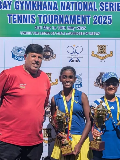 Two champions holding their trophies. Trisha Bhosale and her doubles partner after their victory at the Bombay Gymkhana National Series. We emphasize strong doubles strategy in our training.