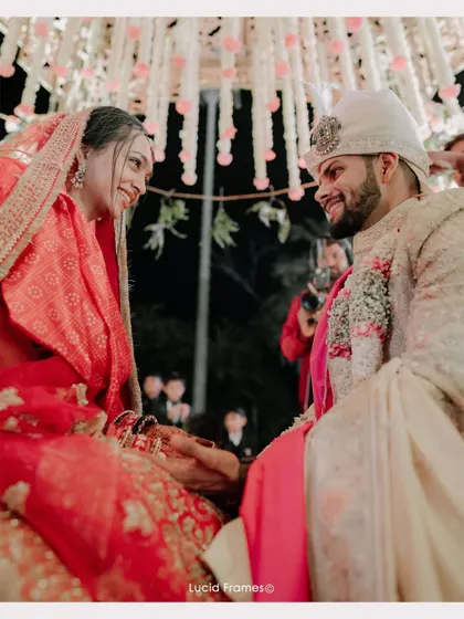 A quiet, intimate look shared between the bride and groom amidst the grand celebration.