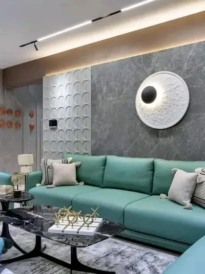 Another view of the living room, highlighting the layered textures and materials used, from the stone-cladding on the wall to the soft fabrics of the sofa.