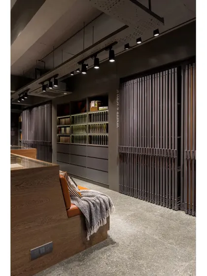 The showroom features multiple display systems, including these sliding panels and open shelving, allowing for a comprehensive and organized presentation of materials.