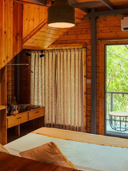 The interior of our wooden cabins is designed to be a rustic yet comfortable retreat, with large windows that bring the beauty of nature indoors.