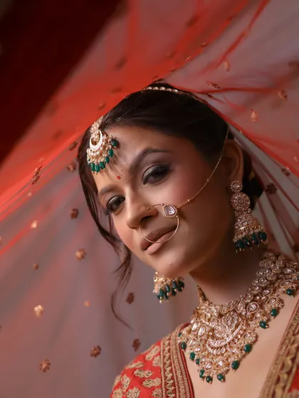 A classic bridal portrait. The focus is on the eyes, which are accentuated with a winged liner and soft shimmer, paired with a traditional bindi and nath.
