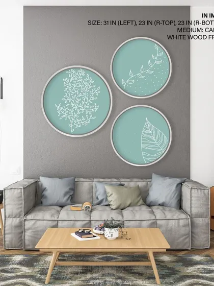 A delicate set of three circular prints featuring white botanical line drawings on a soft teal background. The white wood frames enhance the light and airy feel, perfect for a calm and modern space.
