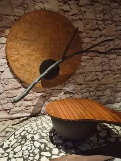 A close-up of the artistic details in one of our landscape designs, featuring a custom wall art piece and a uniquely shaped wooden bench, perfect for creating a statement.