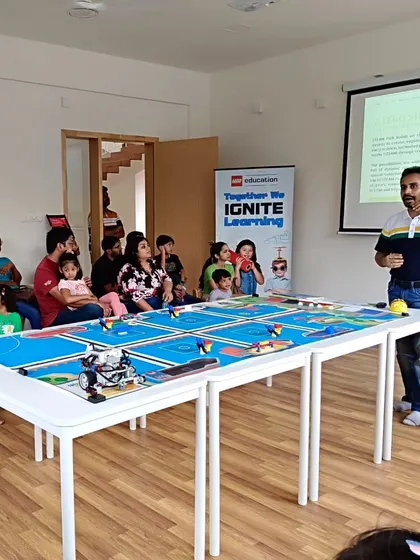 An instructor uses the challenge mat and a presentation to explain our LEGO Education programs during a parent orientation session.