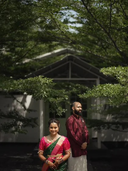 A classic couple portrait framed by the lush green leaves of trees. This timeless shot is perfect for capturing a simple, elegant moment together.
