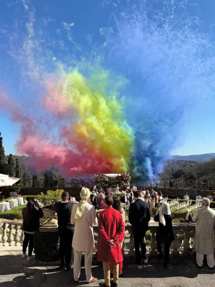 A massive burst of rainbow colored smoke during an outdoor ceremony in Tuscany. This is a perfect example of using special effects to create a spectacular, photo worthy moment.