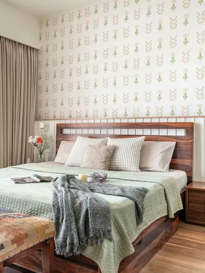 A full view of the bedroom, showing the custom bed with storage and the matching bedside tables. The subtle floral wallpaper adds a touch of elegance without overwhelming the space.