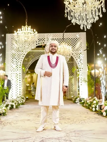 A stylish portrait of the groom at the entrance of the wedding venue.