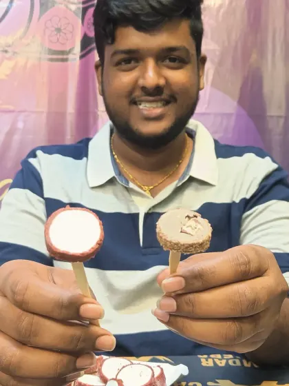 A happy guest showing off our unique ice cream kulfi pops, a cool and refreshing treat after a spicy meal.