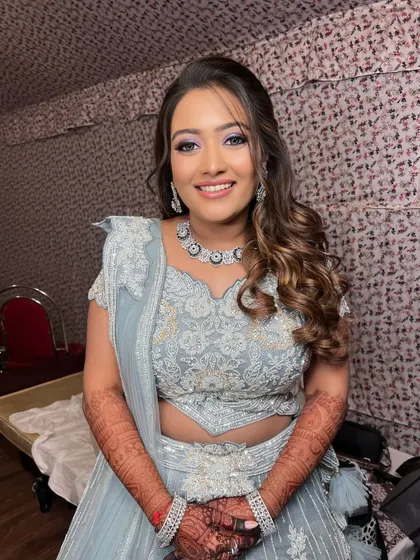 A beautiful look for a sangeet or reception in a powder blue lehenga. The makeup is fresh with a pop of purple on the eyes.