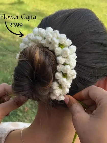 A close-up of our classic white flower gajra being styled in a bun. It's a timeless accessory for any traditional occasion, available for just 399.