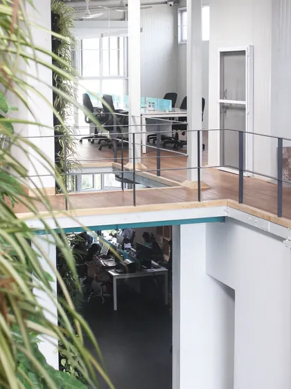 A view through the central void in our office, looking from one level to another. This open, double-height space promotes visual connectivity and a sense of community among our team.