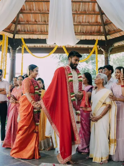 The couple taking their first steps together after the ceremony, surrounded by the blessings of their elders.