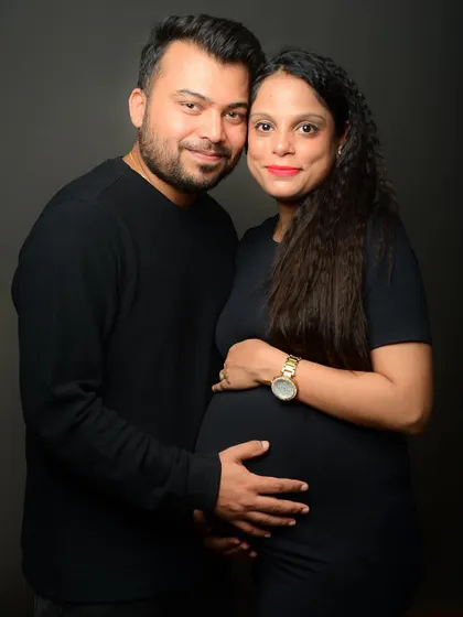A warm and loving portrait of an expecting couple. Their smiles and close embrace radiate happiness and anticipation.
