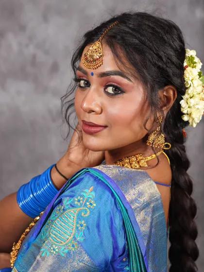 A direct and engaging portrait in a blue saree. The studio lighting ensures the colors are rich and true to life.
