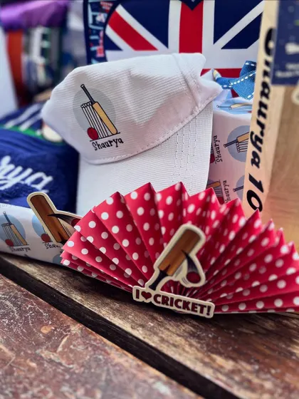 A custom-printed cap and themed paper fan, showing how every element contributes to the story.
