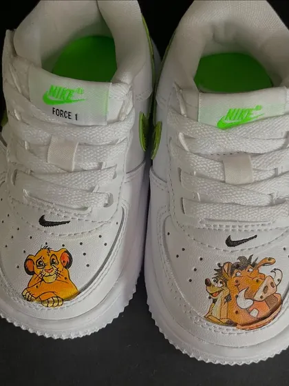 A close-up of the custom Lion King sneakers for kids, featuring Simba and Timon & Pumbaa on the toes.
