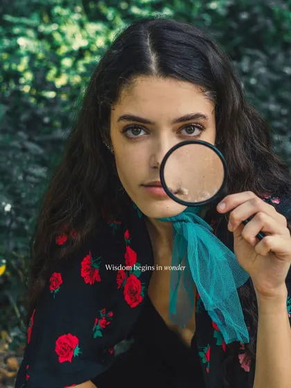A creative portrait using a magnifying glass to draw focus and add an element of wonder. Props can be a fun way to express personality and create a unique and memorable image.