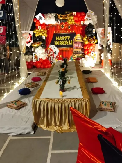 Another angle of the casino-themed Diwali party, showing the long table setup under a canopy of fairy lights.