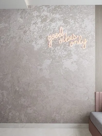 This modern minimalist room features a cozy daybed with a neon sign, creating a cool and personalized hangout spot for a young adult.