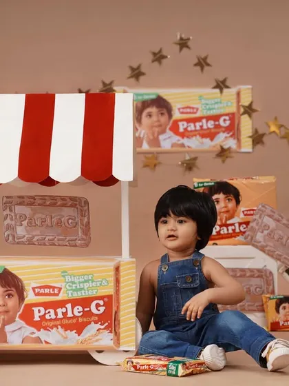 The full setup of the nostalgic Parle-G themed birthday shoot, with the baby girl sitting by a custom-made biscuit stall.