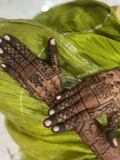 A beautiful back of hand design with a focus on traditional motifs like elephants and checks. The dark, rich stain makes the intricate details pop against the skin.