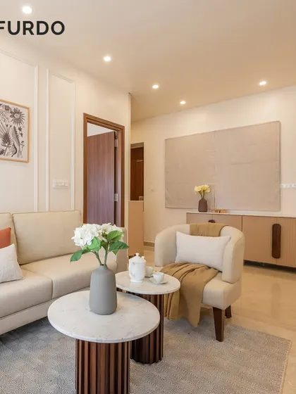 A bright and serene living room with a neutral color palette. We paired a comfortable sofa with a stylish armchair and nested coffee tables, creating a functional and aesthetically pleasing seating arrangement.