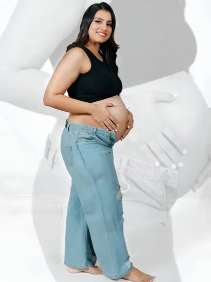 A creative portrait with a faded silhouette of the mother-to-be in the background. This effect adds depth and an artistic touch to a simple, happy pose.