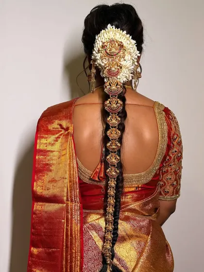 Traditional hair adornments are a key part of the bridal look. This image displays an intricate temple jewellery hair piece, designed to be woven into a braid for an authentic and elegant finish.