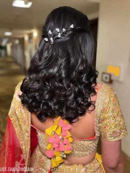 A full back view of the half-updo with butterfly clips, showcasing the beautiful curls and whimsical accessories.