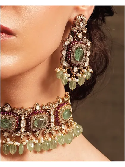 A close-up of the emerald and polki choker, showing the fine detailing on the matching earrings.