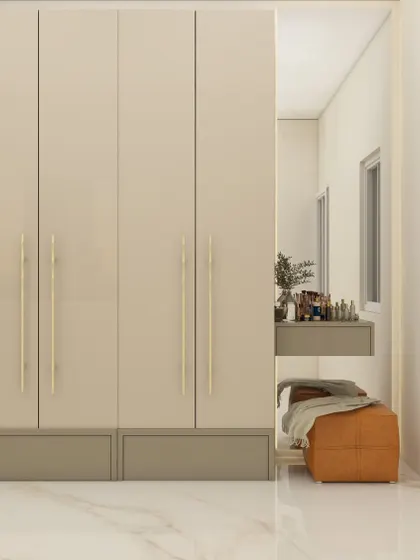 This wardrobe design combines simplicity with elegance, featuring glossy beige doors and long, minimalist handles. A built-in dressing table nook with a mirror makes the space highly functional.