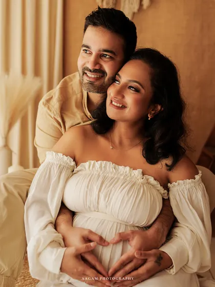 A creative and loving pose, with the couple forming a heart with their hands on the baby bump. A sweet detail in a beautiful lifestyle maternity session.