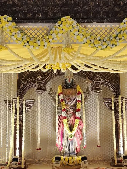 A closer look at the deity and the floral work on the mandap. You can see the layers of tuberose garlands and the yellow floral arrangements that frame the main arch.
