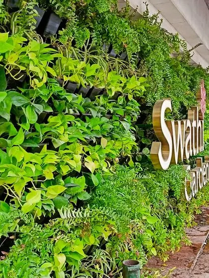 This side view of the Swathi Gardenia vertical garden shows its scale and how it interacts with the urban landscape. These green walls are not just beautiful but also help in reducing noise and air pollution.
