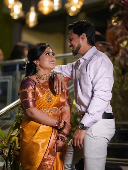 Chaitra and her partner. This photo gives a good view of her engagement look, including the neatly draped saree and elegant hairstyle.