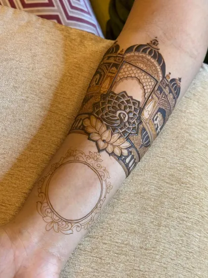 The process of creating a beautiful architectural design on the arm, with a blank frame ready for a personalized portrait.