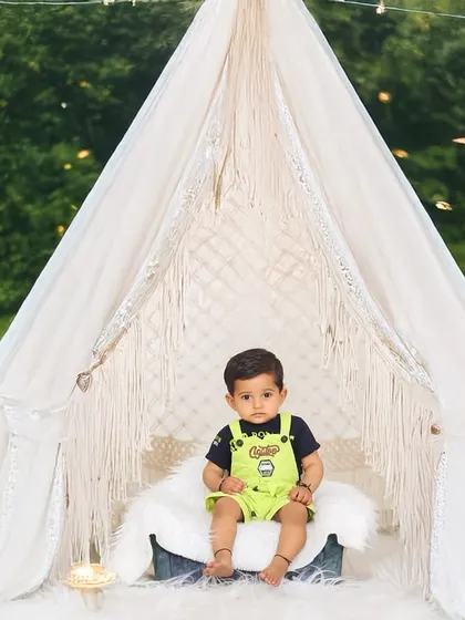 A magical twilight outdoor session. The glowing star props and teepee create an enchanting atmosphere for this little boy's portrait in the park.