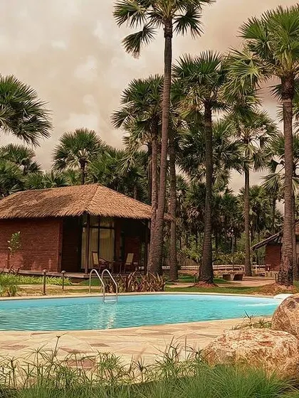 These resort villas are nestled within a coastal oasis of palm trees. The design uses traditional thatched roofs and locally sourced materials to create a tropical retreat that feels both authentic and luxurious.