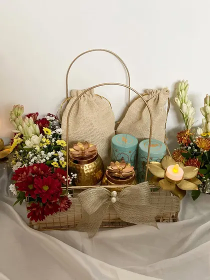 A beautiful setup of our Diwali Treats baskets. These metal baskets are adorned with fresh flowers like rajnigandha and chrysanthemums, along with candles and jute potlis for a traditional yet elegant feel.