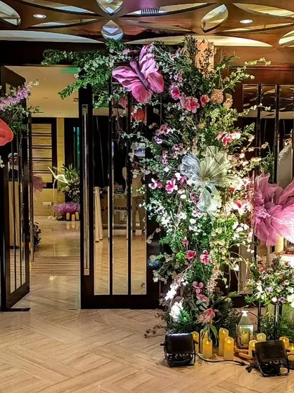 An enchanting entrance for a whimsical Sangeet. I used oversized, colorful butterflies nestled within lush floral arrangements and surrounded by candles to create a magical and theatrical welcome for guests.
