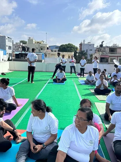 Students resting and chatting between sessions during our International Yoga Day event in Bangalore. This photo captures the friendly and relaxed community atmosphere we foster.