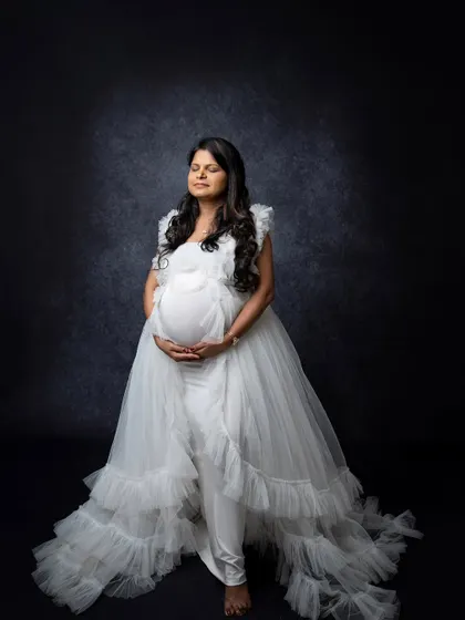 A moment of quiet reflection. This portrait captures the mother-to-be with her eyes closed, connecting with her baby in a serene and personal way.
