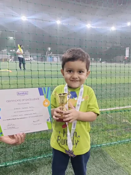 A champion in the making. A young boy proudly holds his trophy and certificate of excellence after participating in our 'Health is Wealth Day' events.