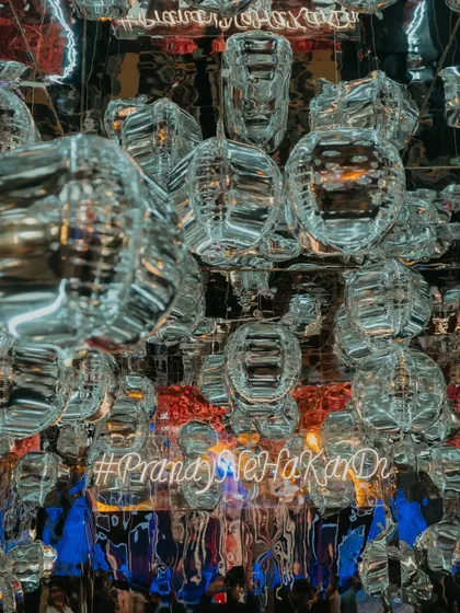 A creative photo-op with a ceiling of silver balloons and a custom neon hashtag, creating a fun and immersive spot for guests to capture memories.