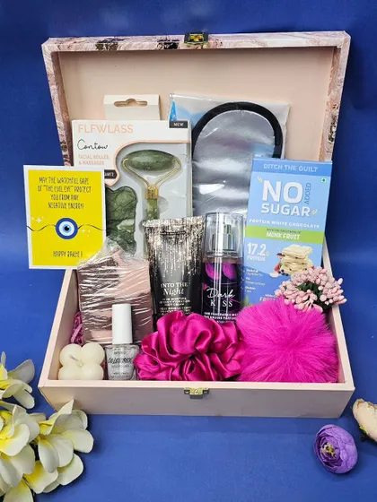 Spoil your sister this Raksha Bandhan with this pamper hamper. It's packed with a jade roller, a silk eye mask, body mist, nail polish, and healthy snacks, all inside a beautiful wooden box.